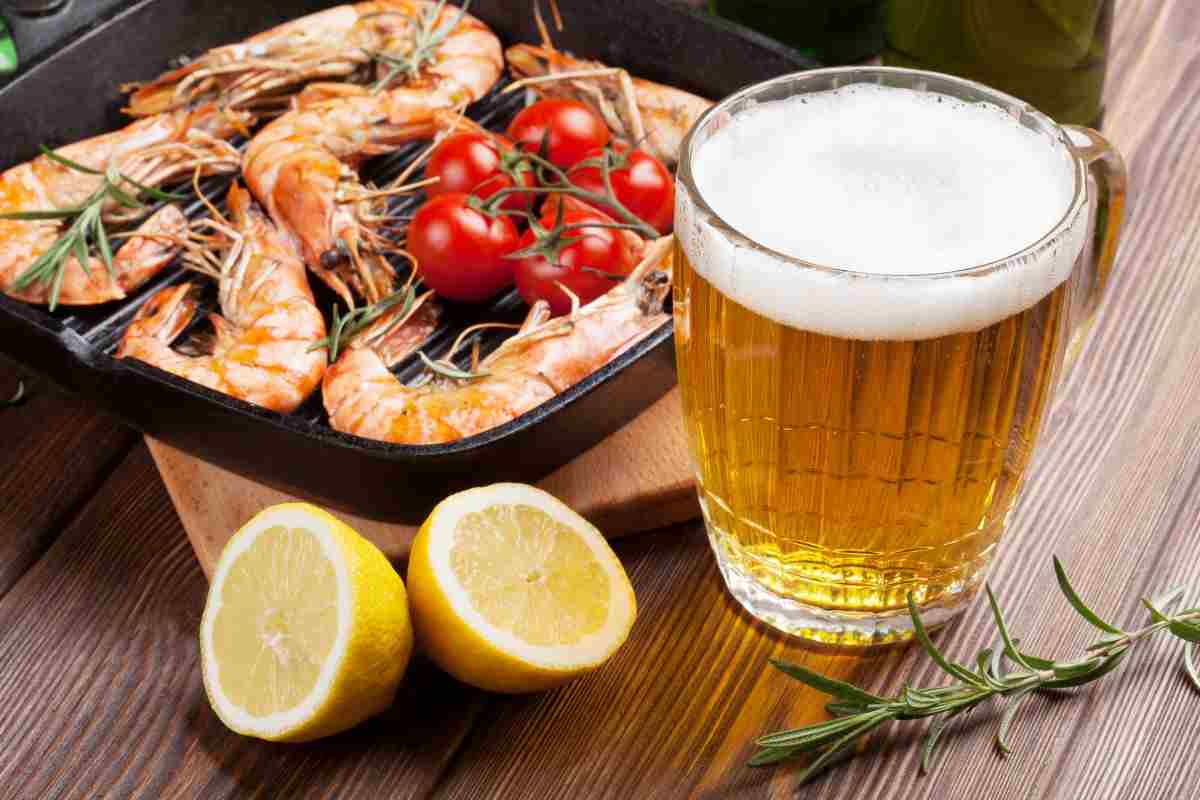 Boccale di birra e gamberi in padella